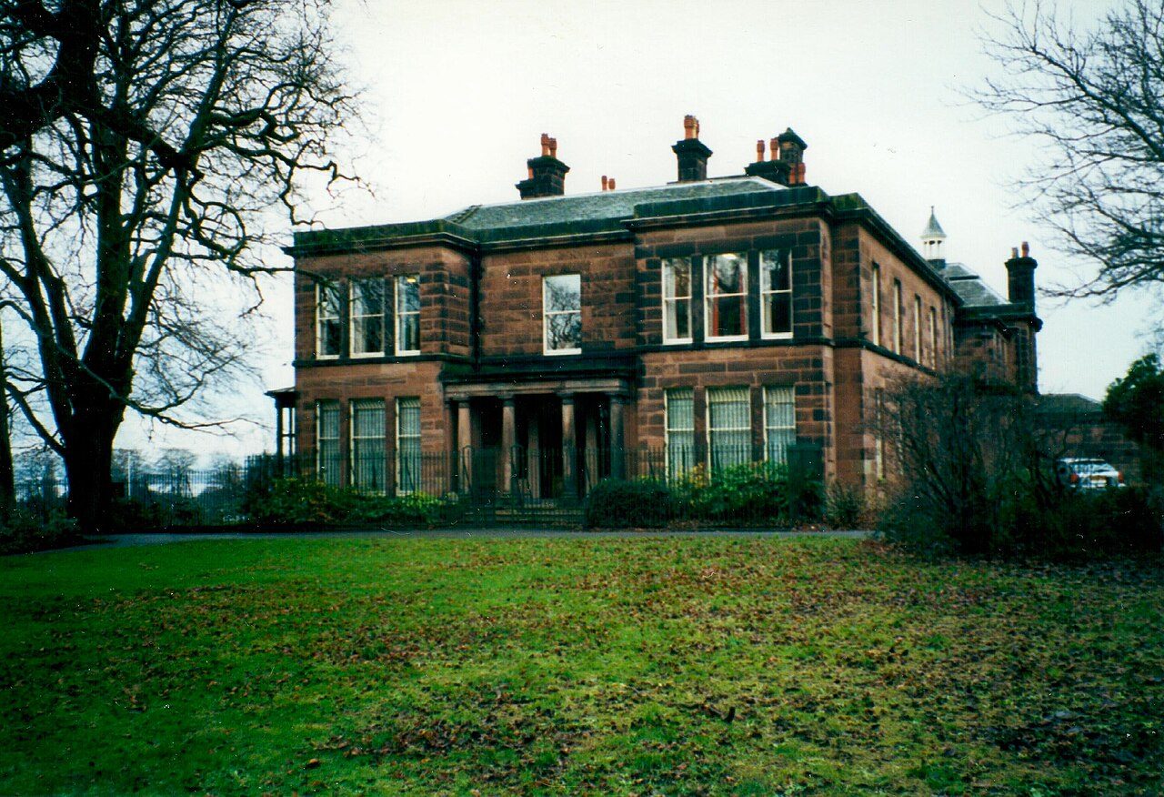 Sudley House, a red sandstone Victorian villa, seen across its lawn