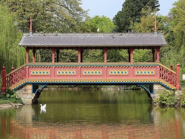 The red Swiss Bridge over the lake in Birkenhead Park